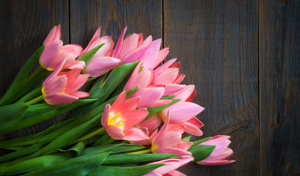 Красивый букет розовых тюльпанов на деревянном столе