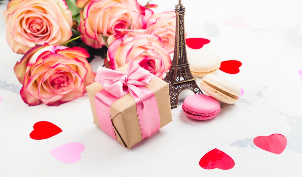 Букет роз на столе с фигуркой Эйфелевой башни и подарком