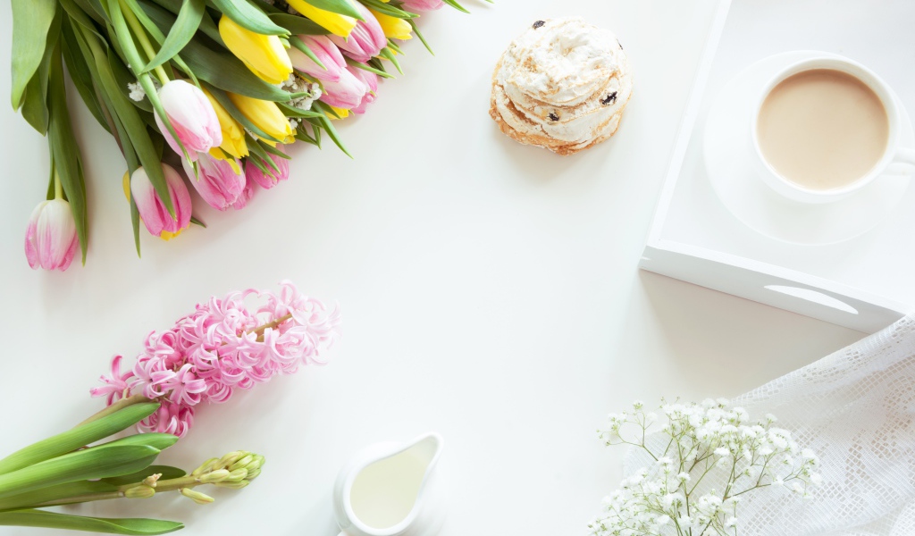 Букет тюльпанов и гиацинт на столе с пирожным и чашкой какао 