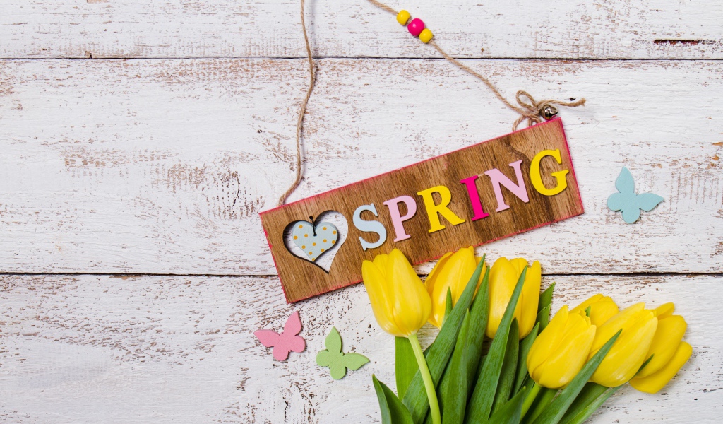 Букет желтых тюльпанов на деревянном фоне с надписью Весна 