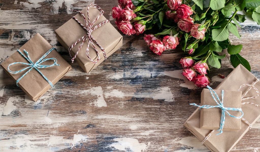 Подарочные коробки на деревянной поверхности с букетом роз