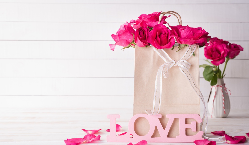 Пакет с розами на столе с надписью Love