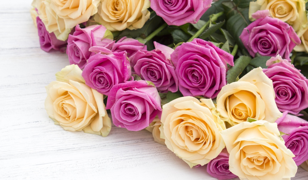 Розовые и белые розы на белом столе 