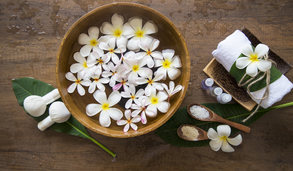 Цветы плюмерии в чаше с водой для SPA процедур 