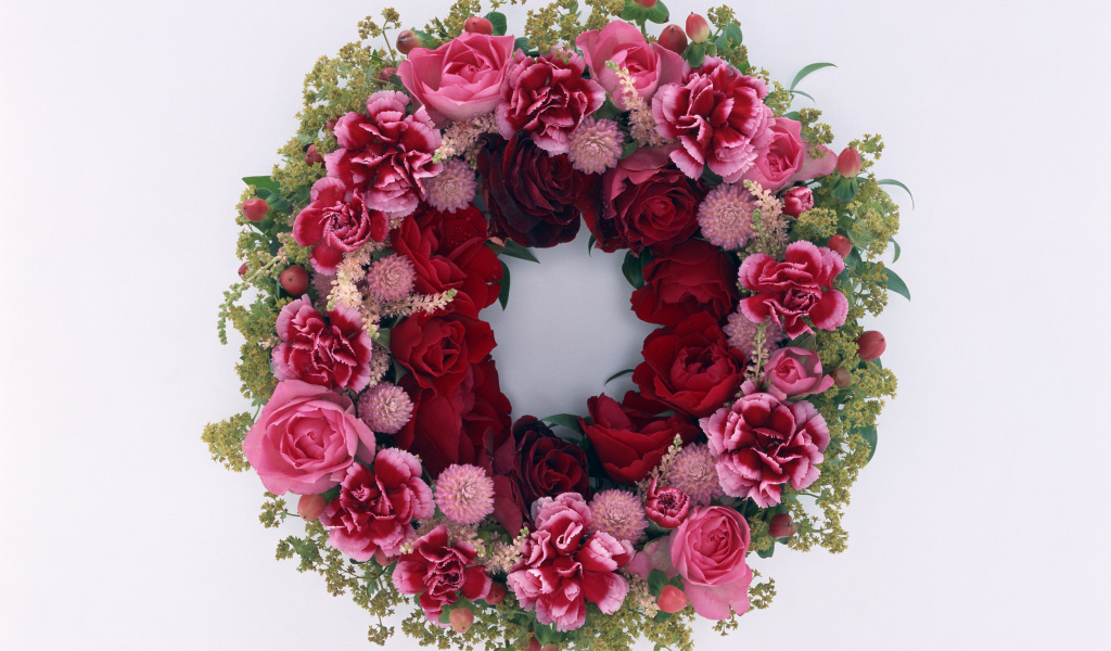 Венок и красных роз с цветами гвоздики на сером фоне