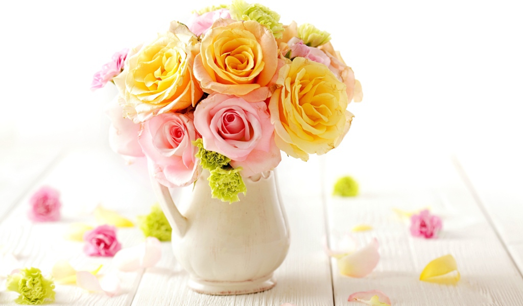 Желтые и розовые розы в вазе на столе 