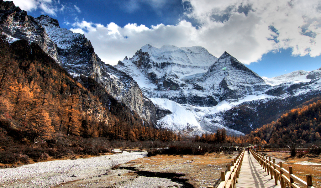 Мост у подножия заснеженных величественных гор