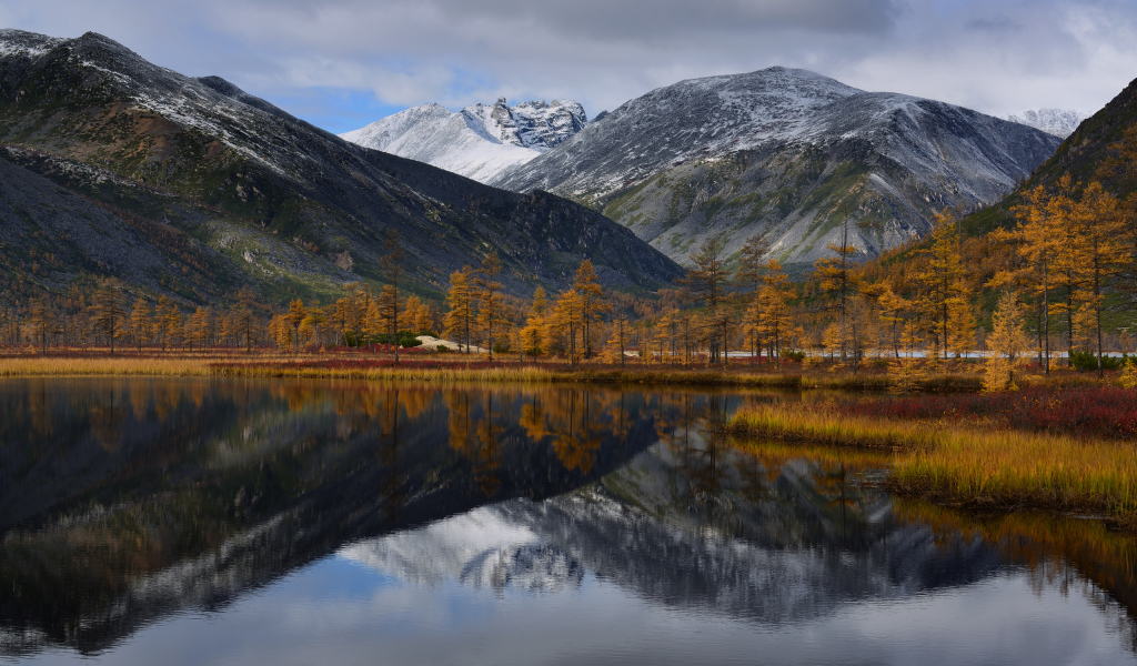 Горы отражаются в глади воды озера осенью