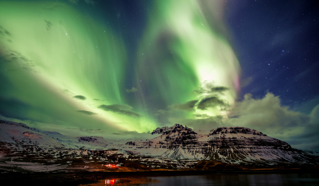 Северное сияние над заснеженными горами, Исландия