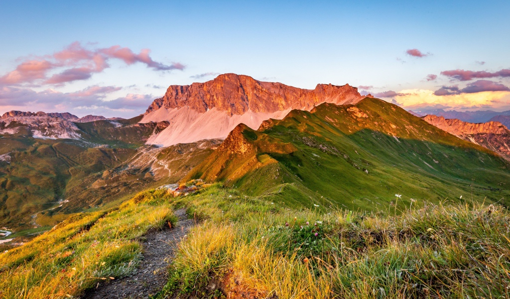 Солнце встает над зелеными горами