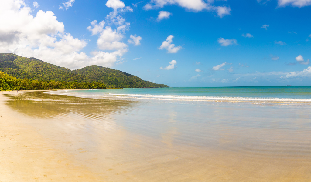 Спокойные волны на песке под красивым голубым небом