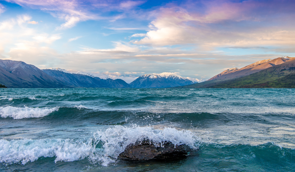 Волны бьются об камни в заливе у гор
