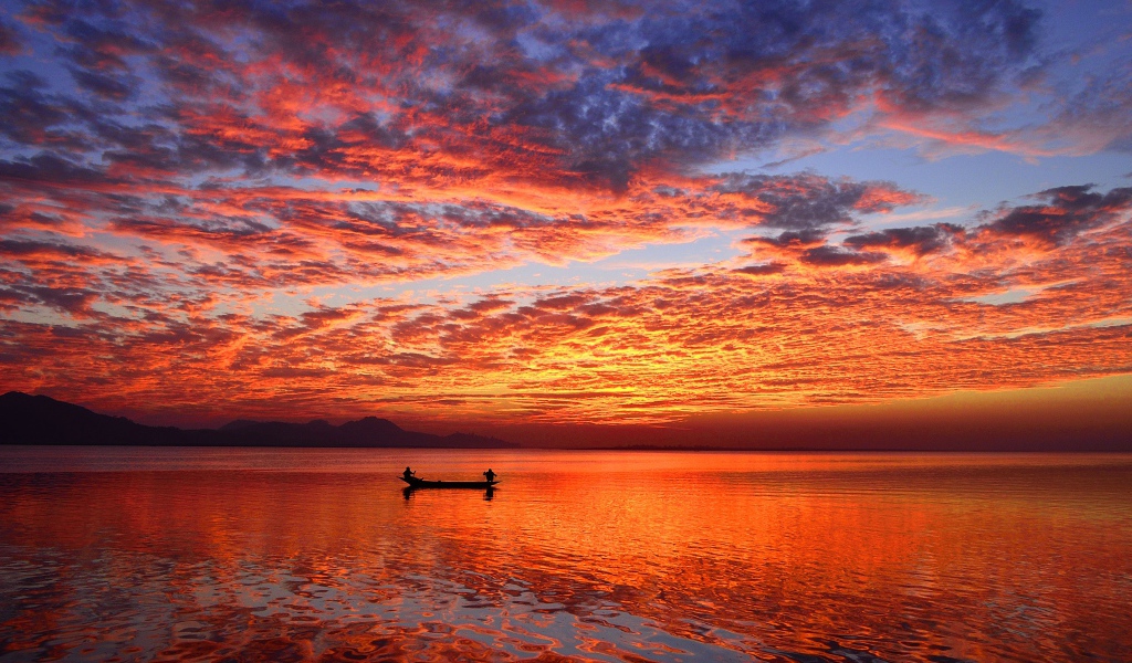 Лодка на воде спокойного озера на закате