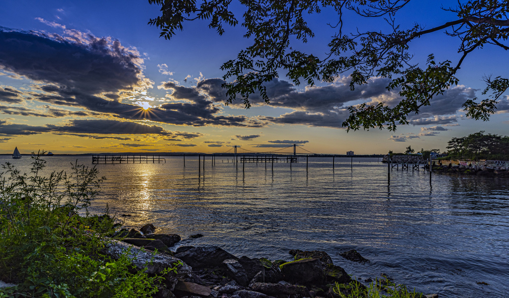 Солнце садится за тучи на горизонте в море