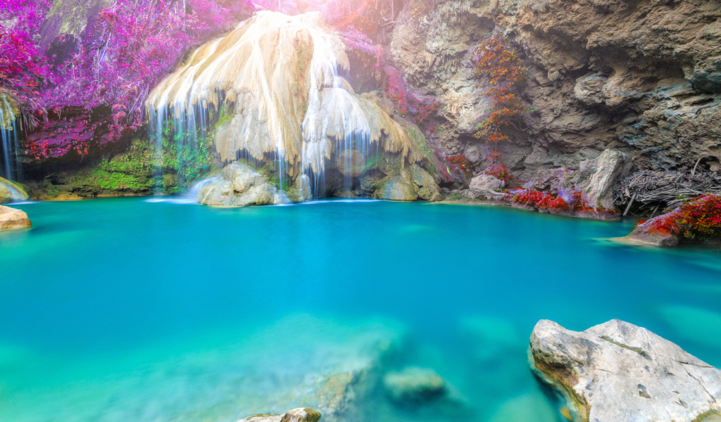 Водопад стекает по скале в голубую воду, Тайланд