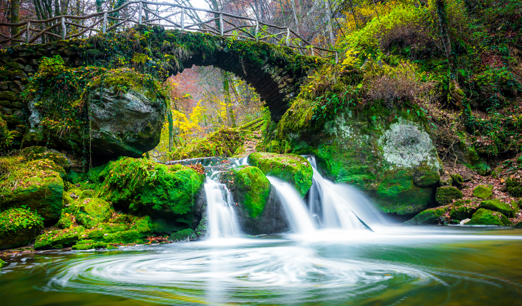 Водопад под старым покрытым мхом мостом