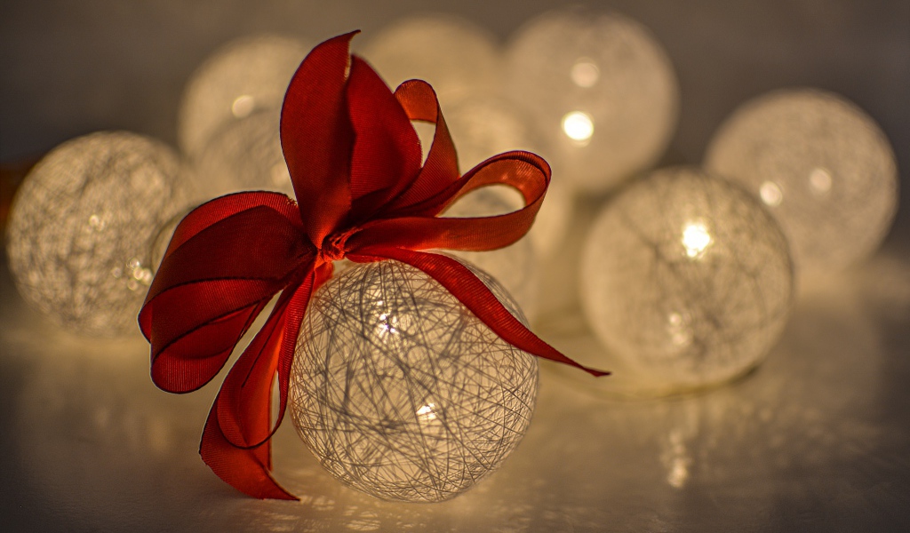 Красивый елочный шар с белых нитей с красным бантом