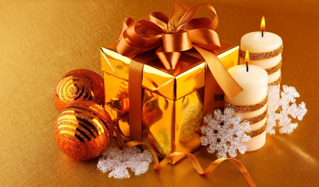 Подарок, елочные шарики и зажженные свечи на новый год 2020 