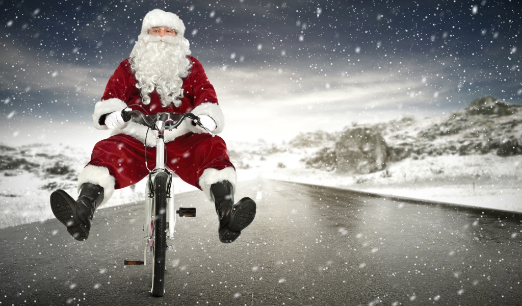 Санта Клаус на велосипеде на скользкой дороге зимой
