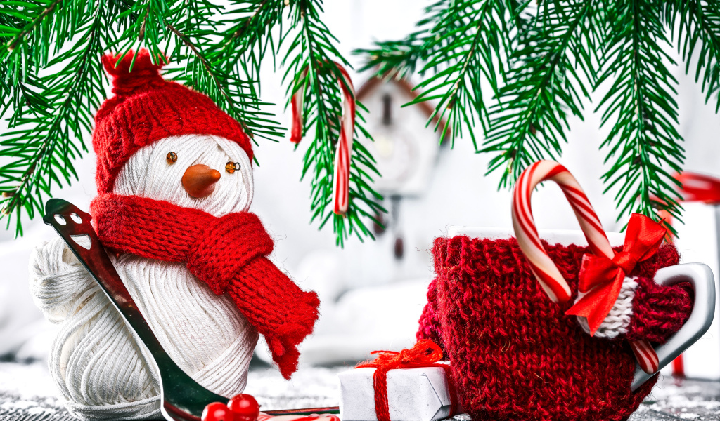 Снеговик из ниток на столе с чашкой и елочными ветками
