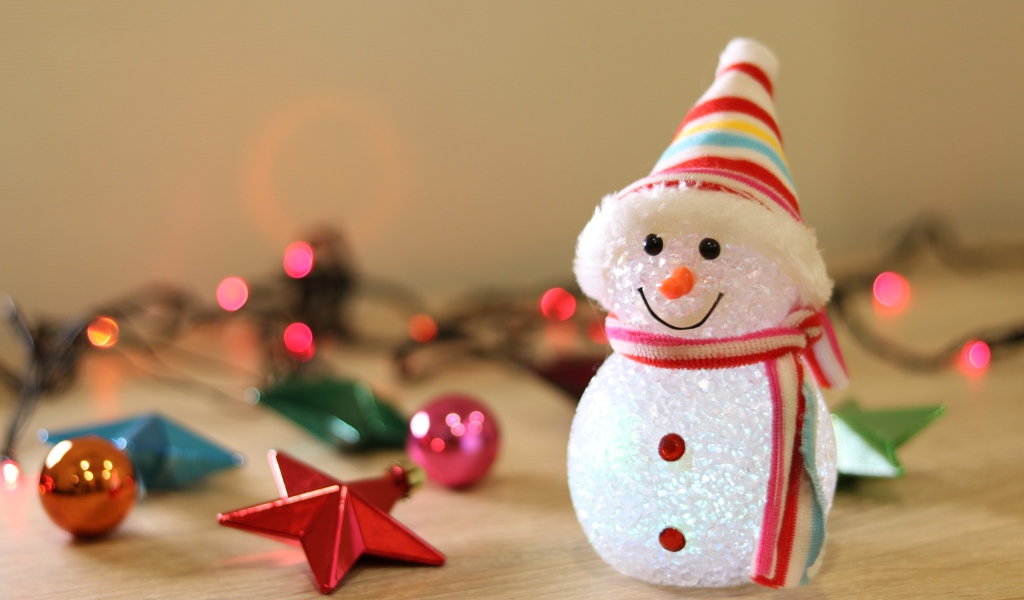 Снеговик с новогодними игрушками на столе