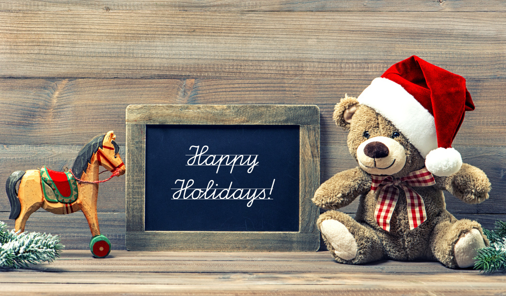 Игрушечный медвежонок Тедди в новогоднем колпаке на деревянном фоне с рамкой