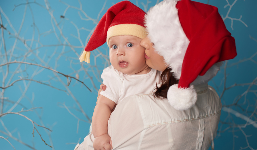 Маленький ребенок в новогоднем костюме на руках у мамы