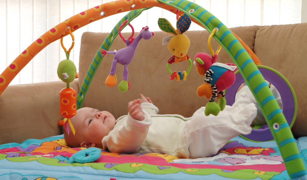 Грудной малыш играет с игрушками