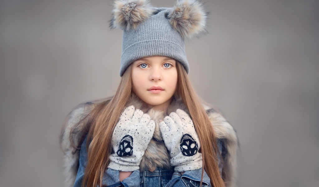 Красивая голубоглазая девочка в теплой шапке