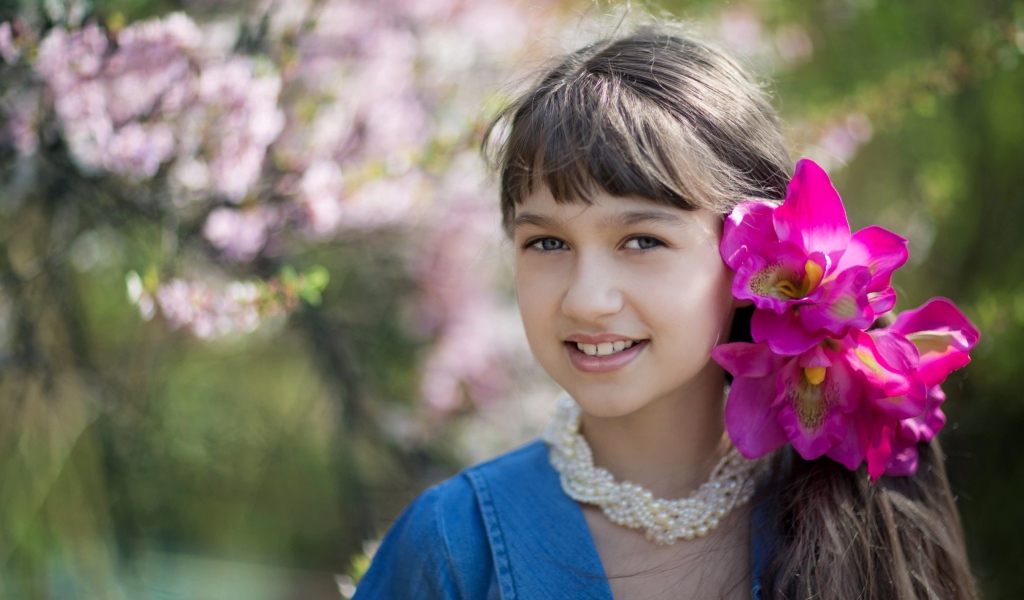 Красивая девочка с розовыми цветами в волосах