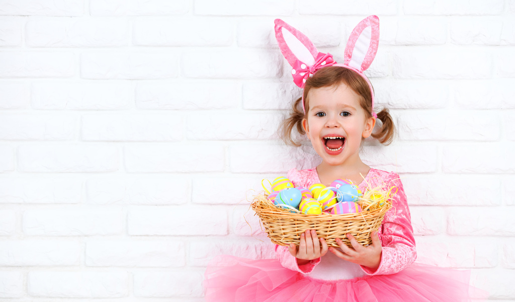 Красивая маленькая девочка в костюме с корзиной крашеных яиц 