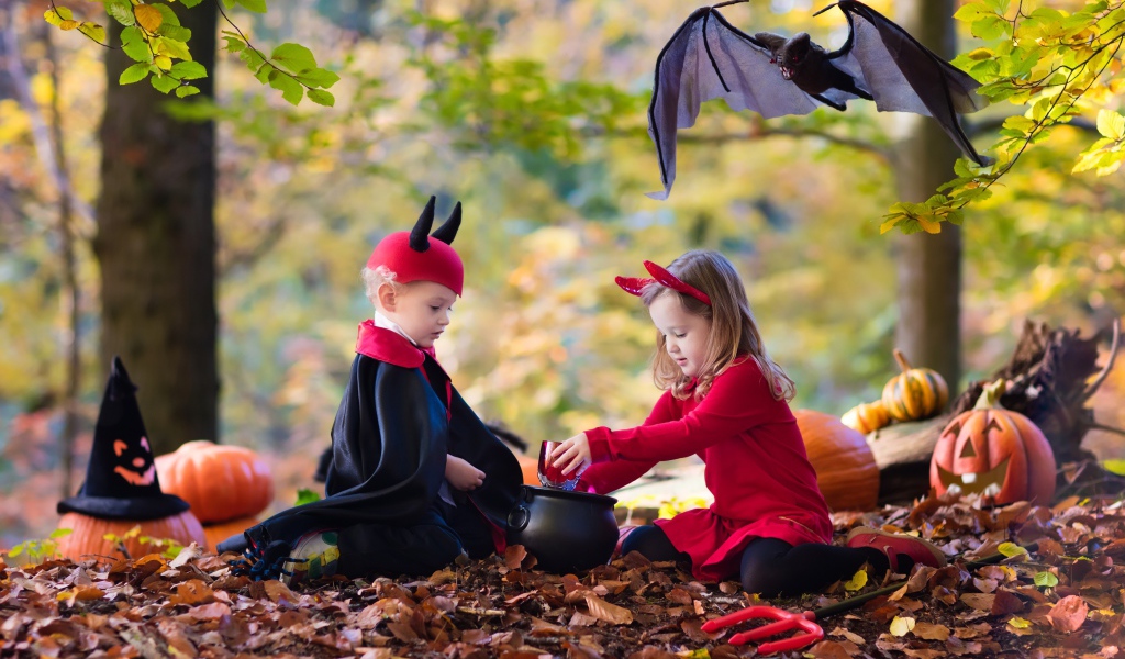 Мальчик и девочка в лесу в костюмах на праздник Хэллоуин 