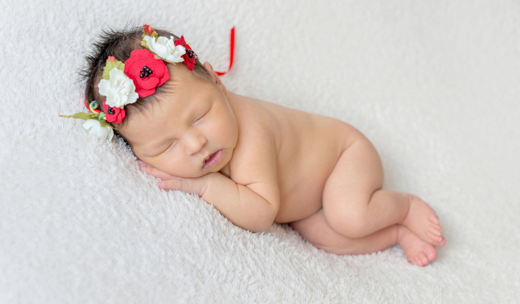 Грудная спящая девочка с венком на голове 