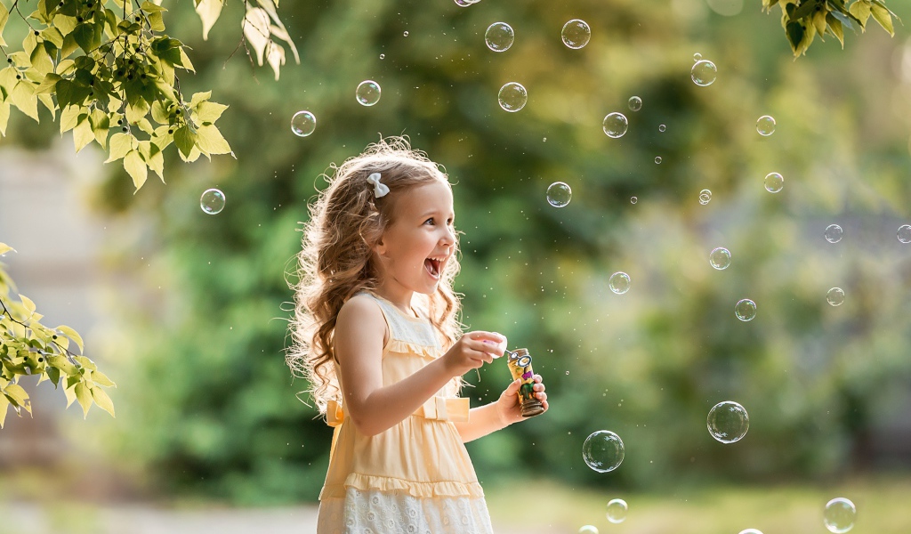 Веселая девочка с мыльными пузырями