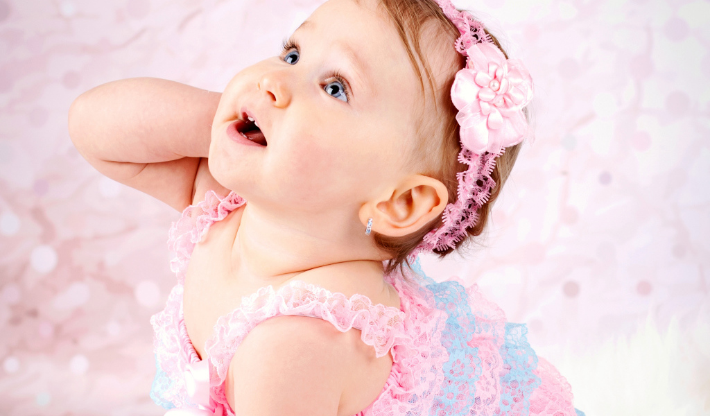 Милая голубоглазая девочка с розовой повязкой на голове