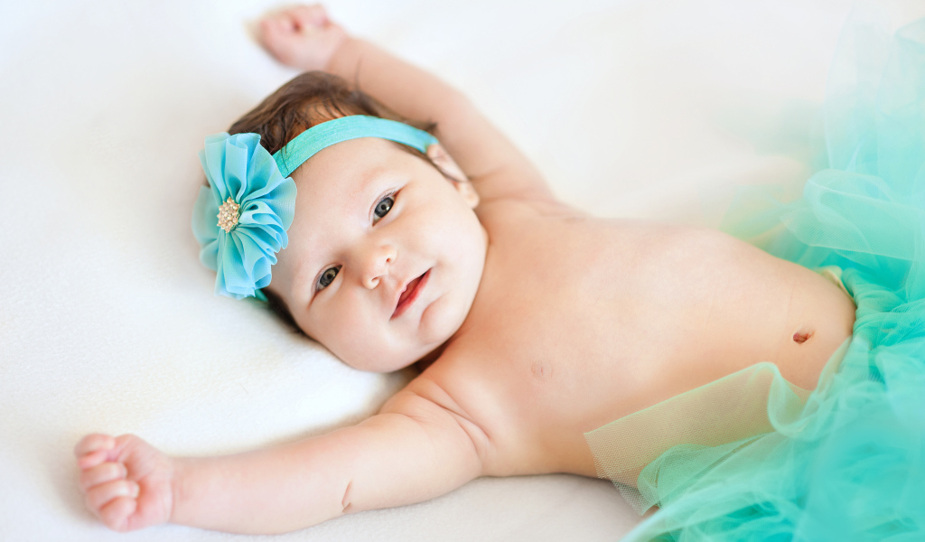 Милая маленькая девочка с повязкой с голубым цветком