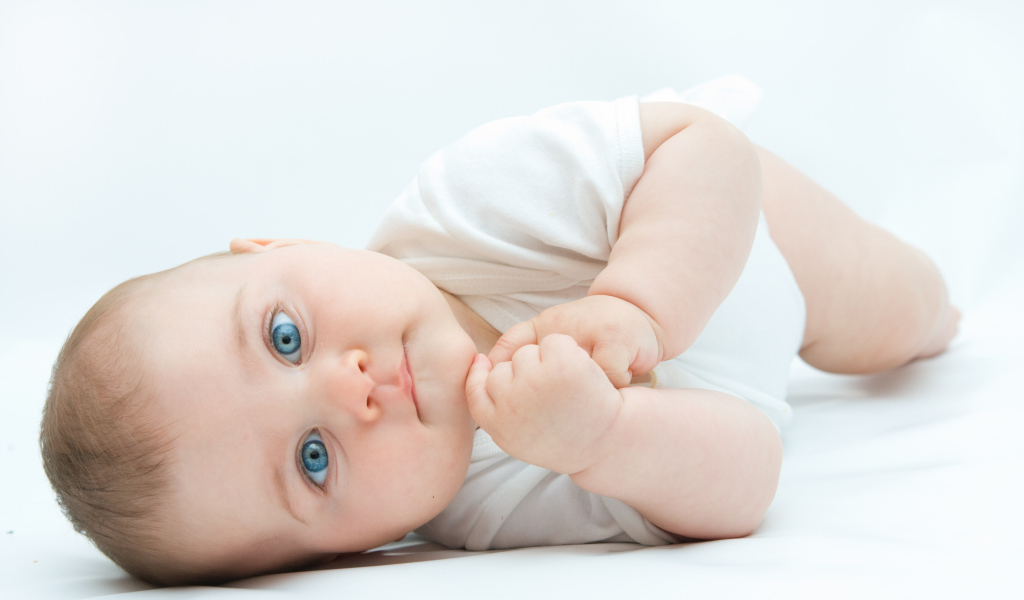 Забавный голубоглазый малыш на белом фоне