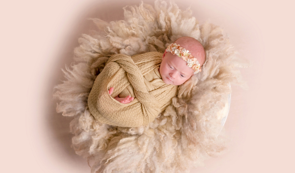 Маленький грудной ребенок завернутый  в покрывало 