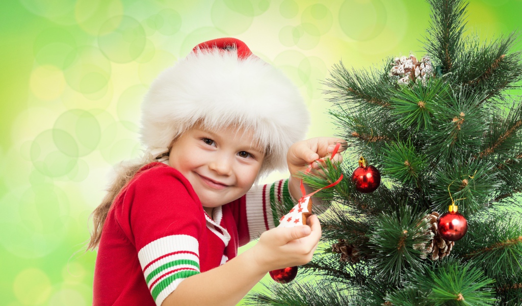 Маленькая красивая девочка наряжает елку на новый год