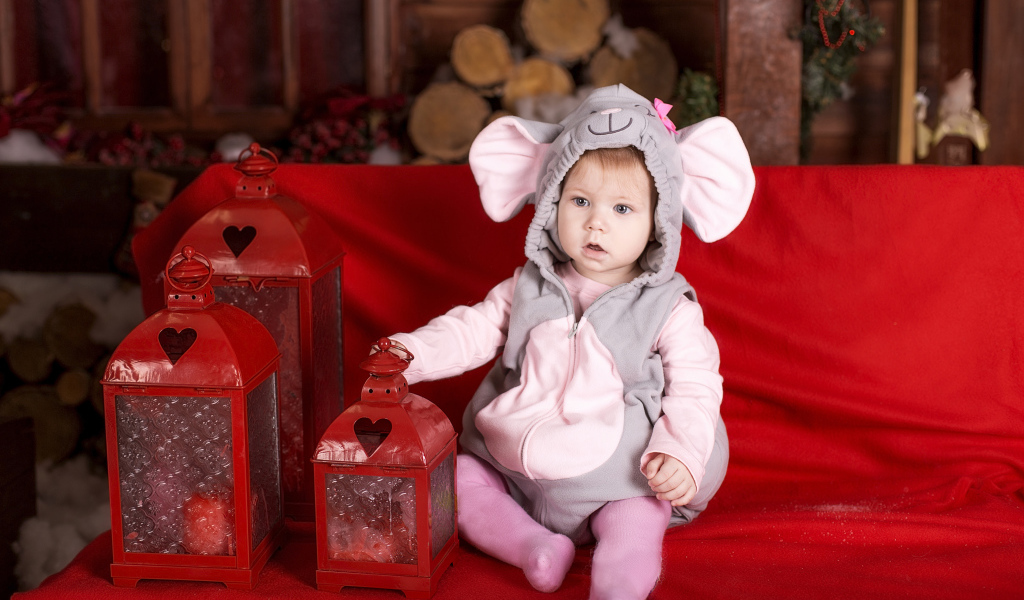 Маленький мальчик в костюме мышонка с фонарями на диване