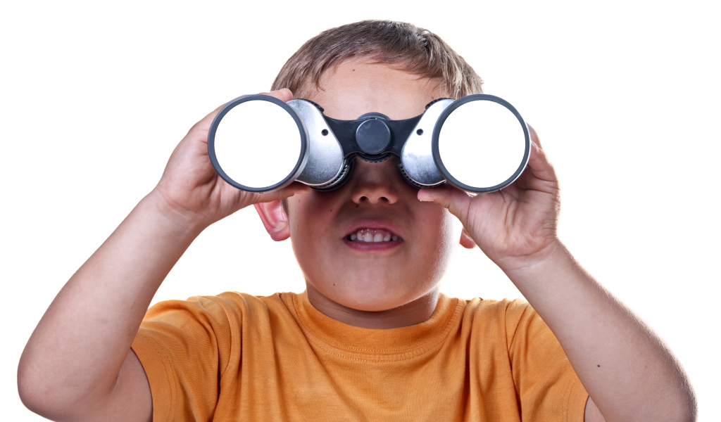 Маленький мальчик с биноклем на белом фоне