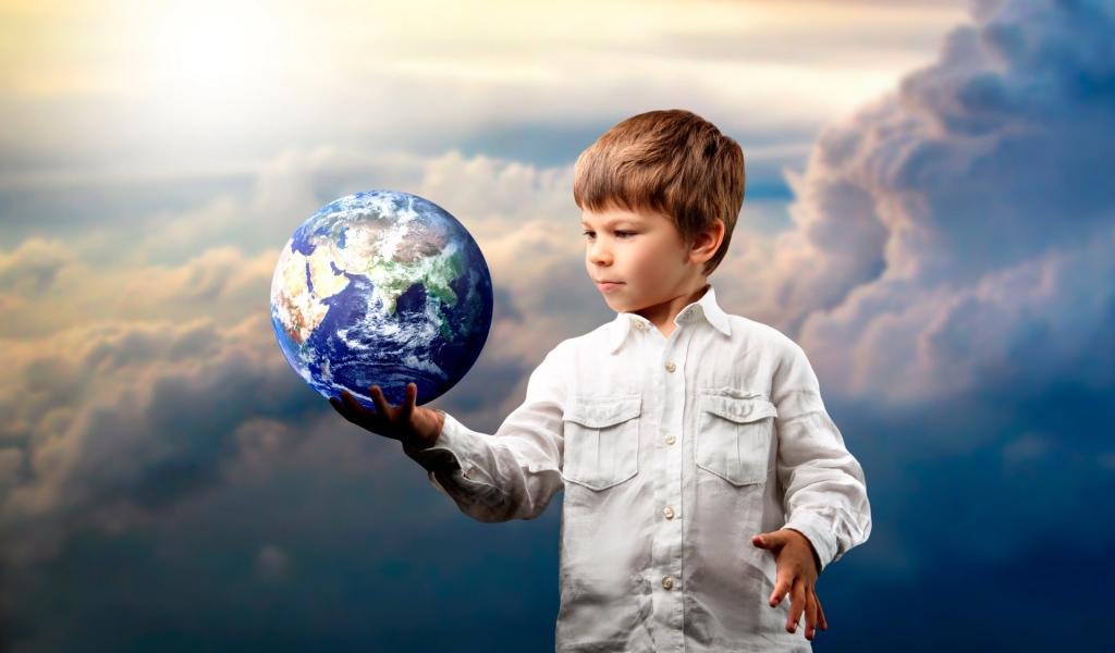 Маленький мальчик с планетой земля в руке