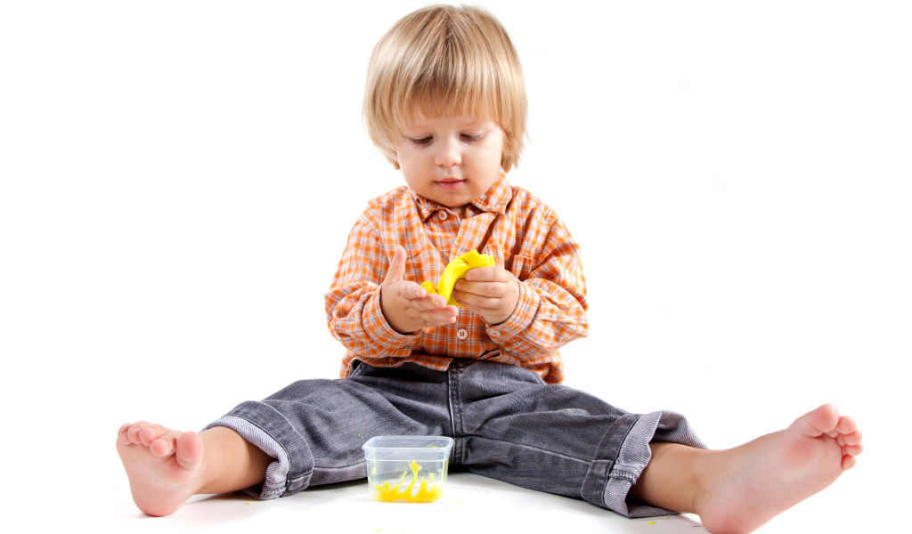 Маленький мальчик с игрушкой на белом фоне