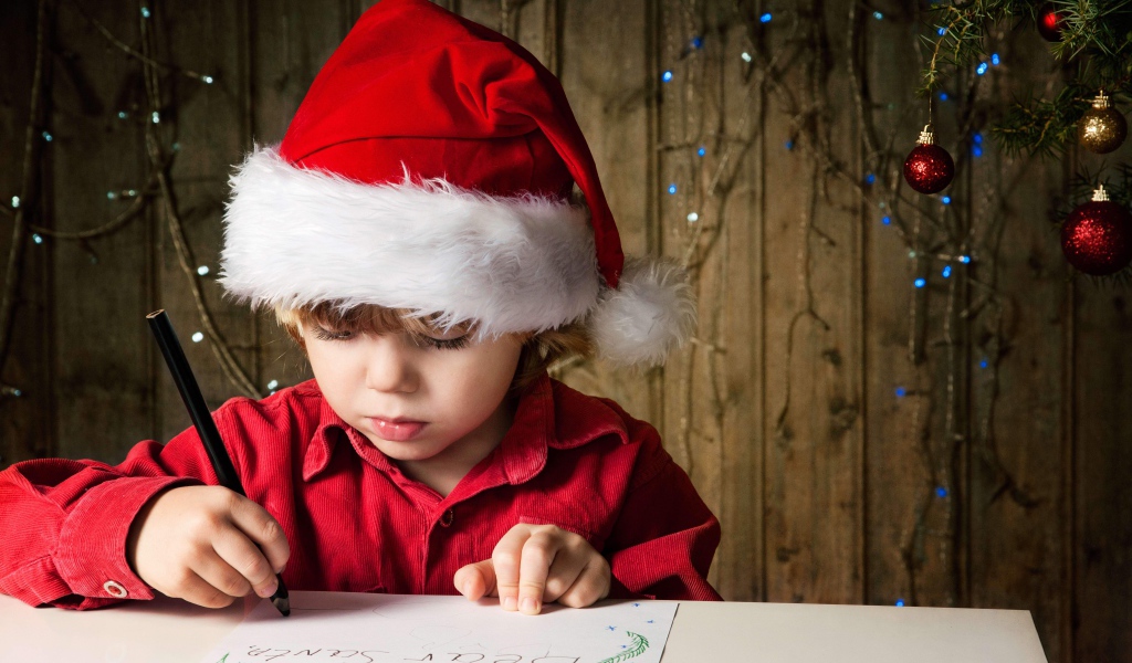 Маленький мальчик пишет письмо Деду Морозу 