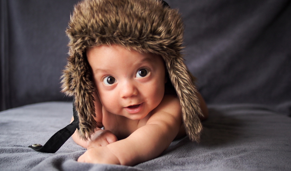 Маленький кареглазый ребенок в теплой шапке