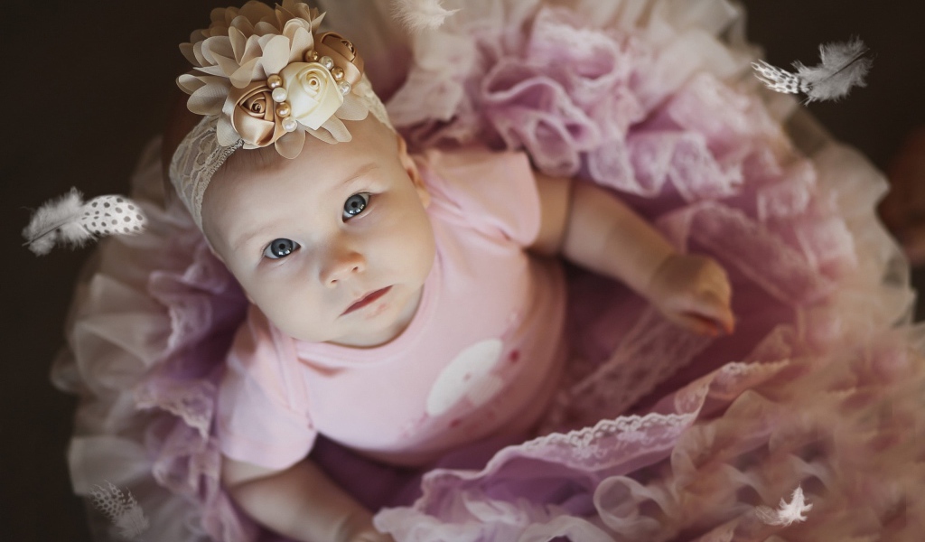 Маленькая милая девочка в пышном платье с повязкой на голове