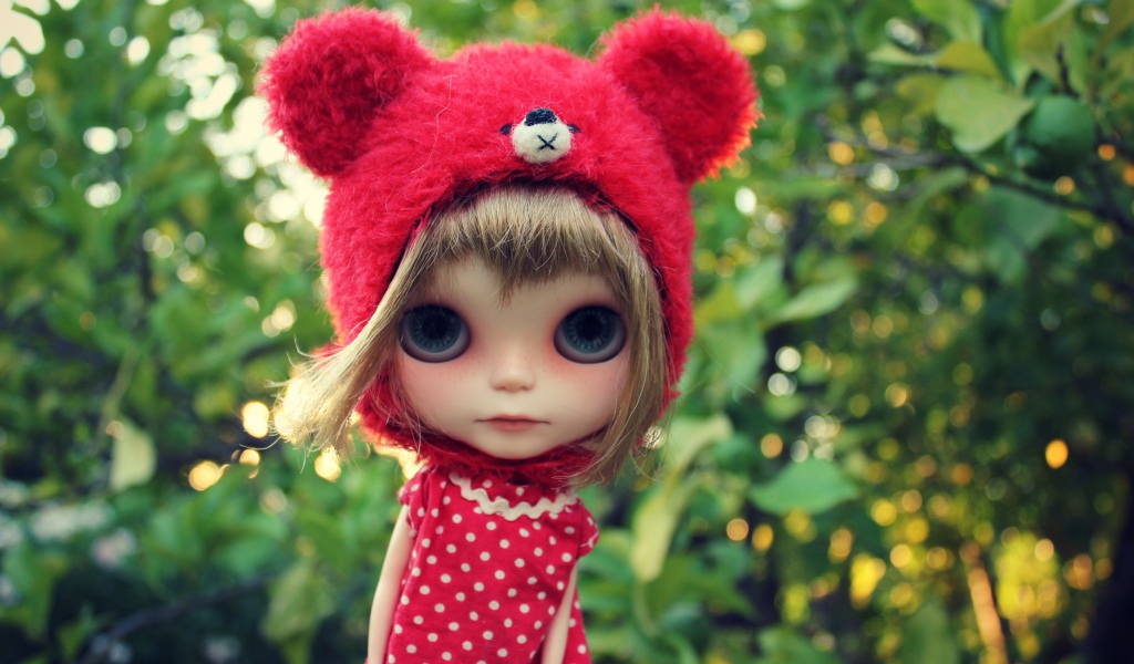 Маленькая кукла с большими глазами в красной шапке