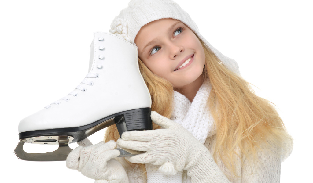 Маленькая девочка блондинка с коньком в руках на белом фоне