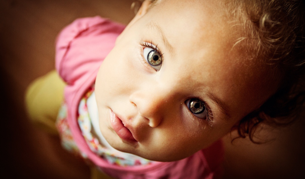 Маленькая девочка крупным планом смотрит вверх 