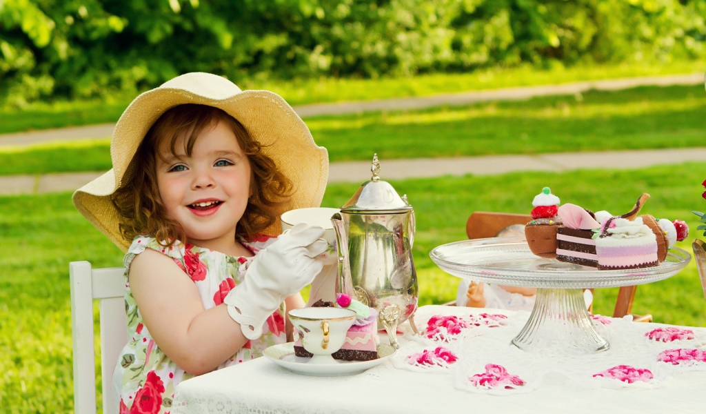 Маленькая девочка пьет чай на природе